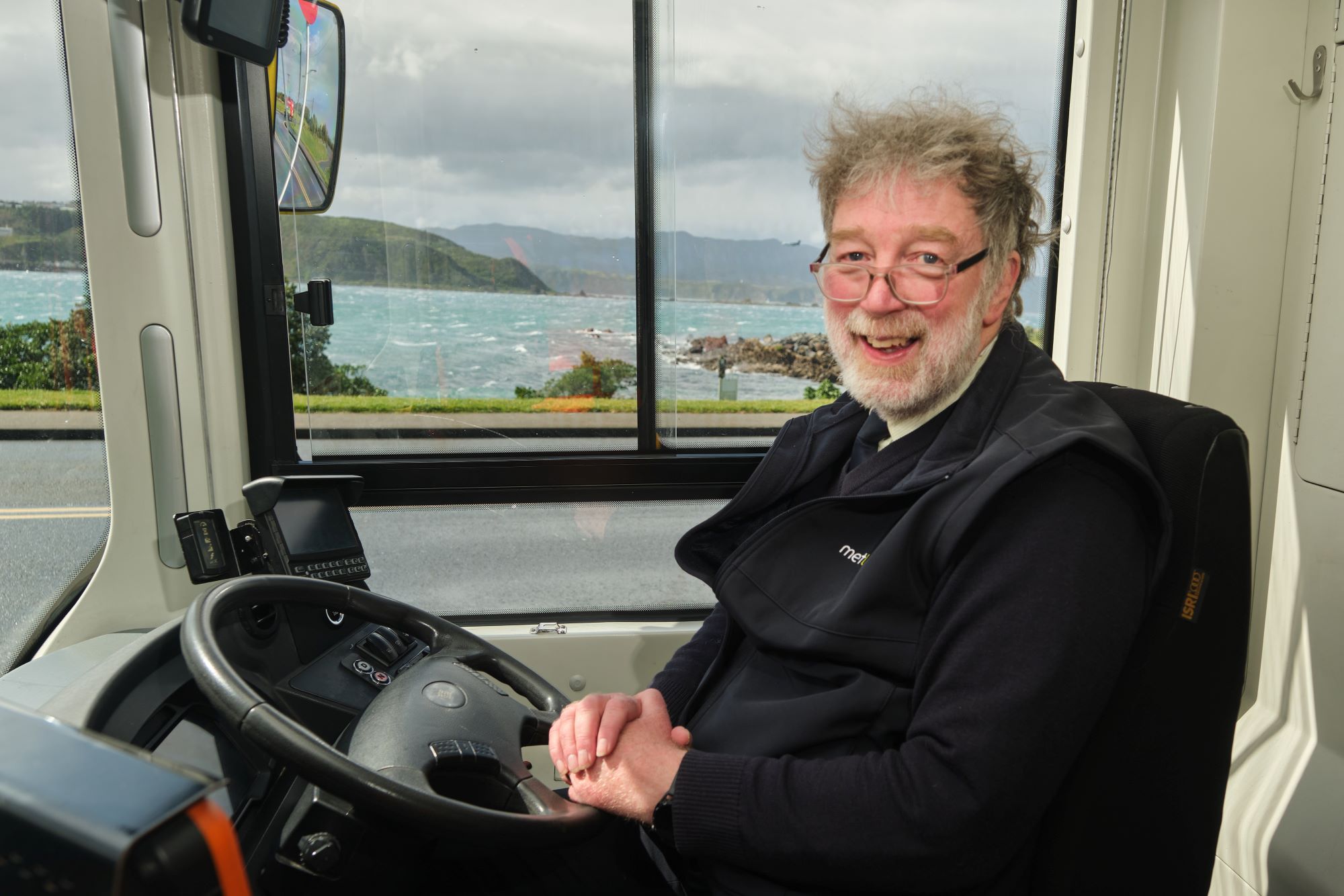Metlink bus driver Peter, smiling at the camera from the driver's seat