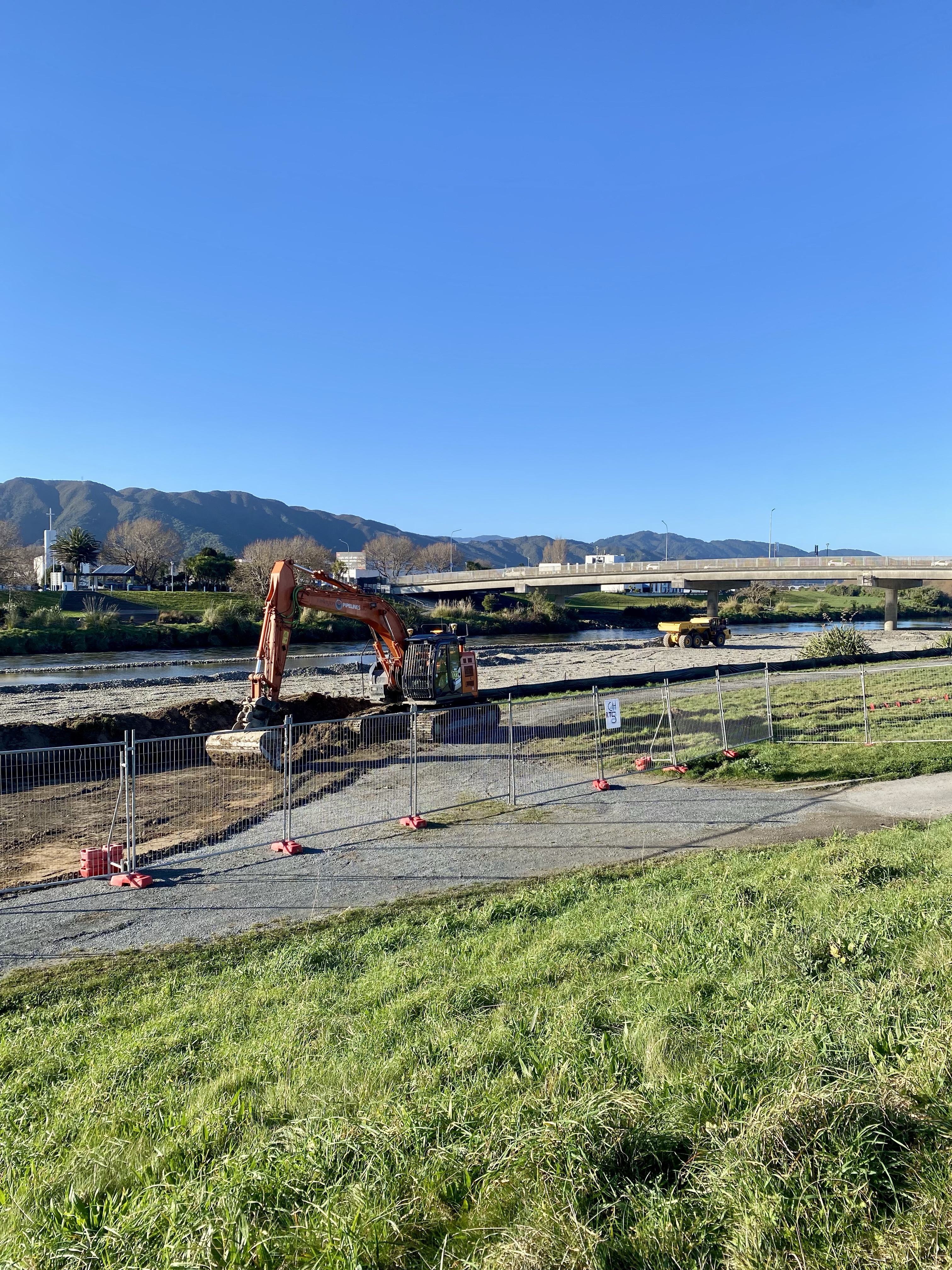 A digger working on a temporary rockline on the bank of Te Awa Kairangi/Hutt River for flood protection